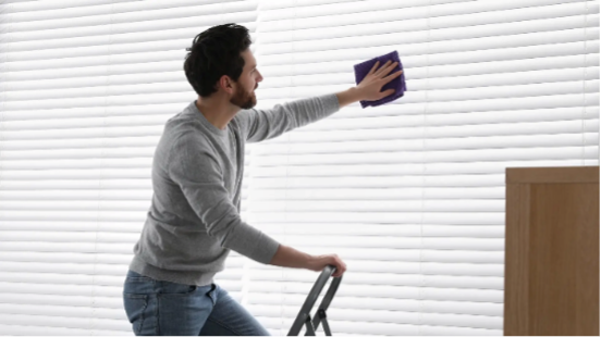 Man Cleaning Apartment Window Blinds